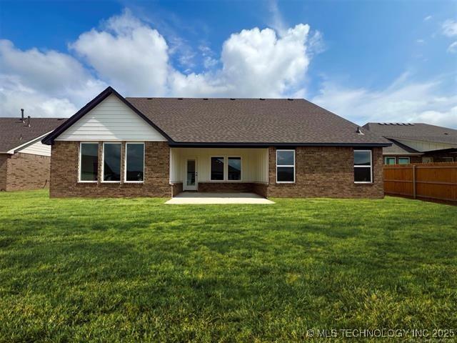 rear view of house featuring a yard and a patio area