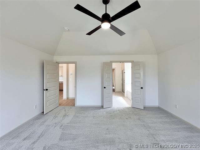 unfurnished bedroom with lofted ceiling, light carpet, and ceiling fan