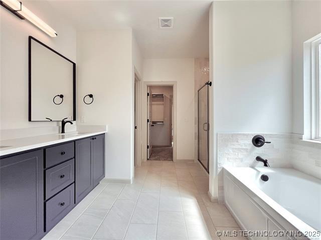 bathroom with vanity, shower with separate bathtub, and tile patterned floors