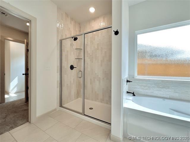 bathroom featuring plus walk in shower and tile patterned floors