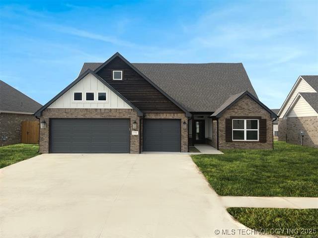 view of front of property featuring an attached garage, a front lawn, board and batten siding, and brick siding