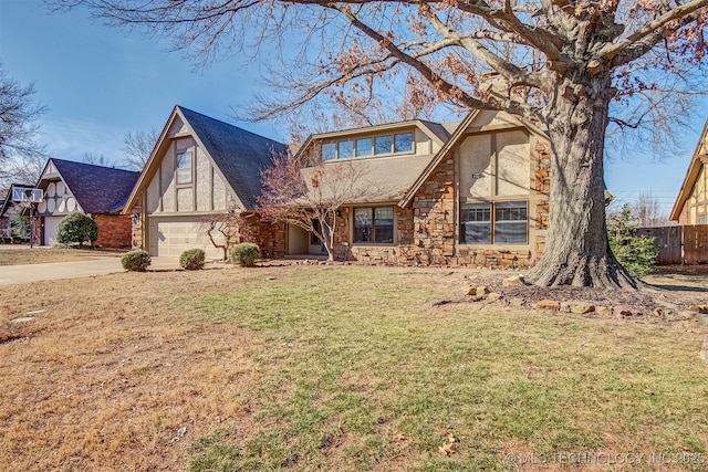 tudor house featuring a garage and a front lawn