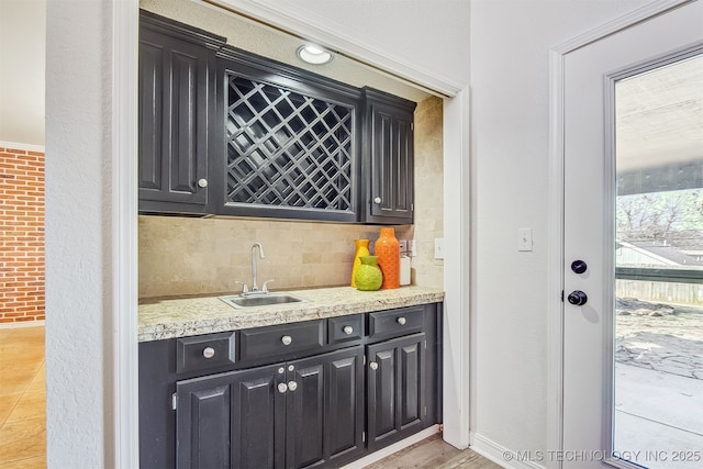 kitchen with brick wall, sink, and backsplash