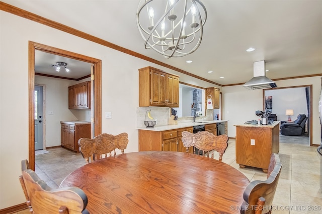 tiled dining space featuring sink, crown molding, and a chandelier