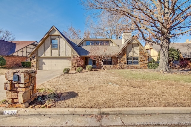 english style home with a garage and a front lawn