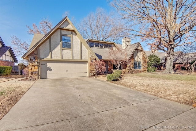 tudor house featuring a garage and a front lawn