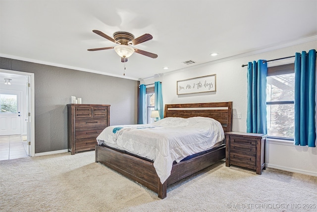 bedroom with ornamental molding, light colored carpet, and ceiling fan