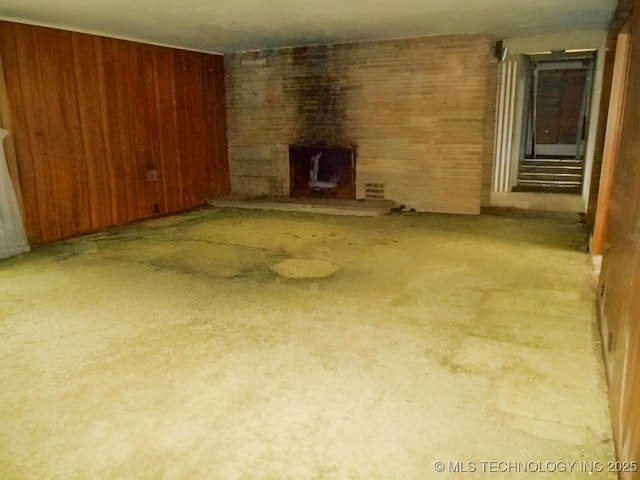 unfurnished living room with wooden walls