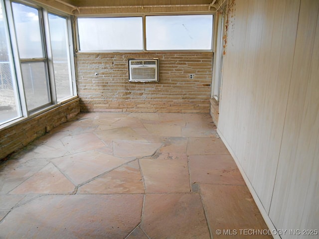 unfurnished sunroom with an AC wall unit