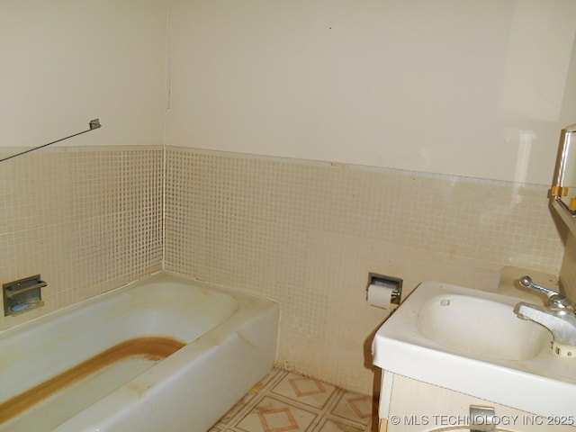 bathroom with sink, tile walls, and a washtub