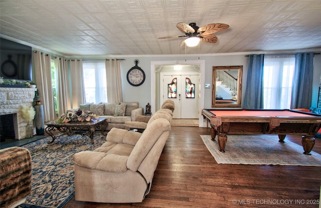 living room featuring a healthy amount of sunlight, dark hardwood / wood-style floors, a fireplace, and french doors