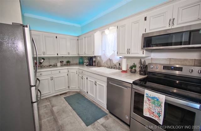 kitchen with white cabinetry, sink, tasteful backsplash, and stainless steel appliances