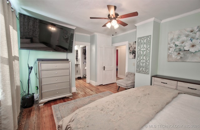 bedroom with crown molding, ceiling fan, and dark hardwood / wood-style flooring