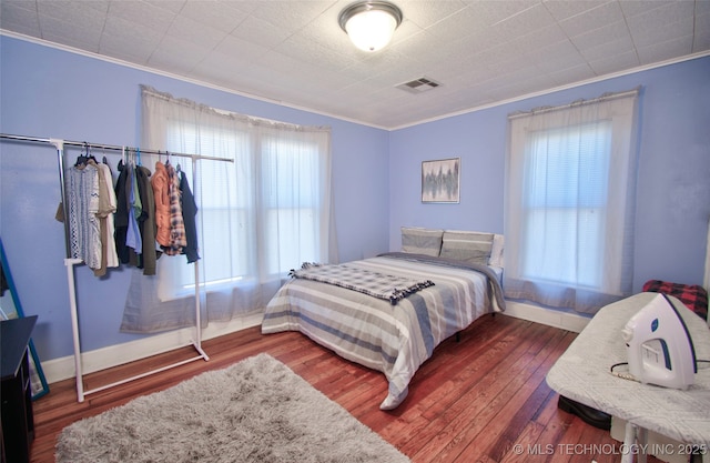 bedroom with wood-type flooring and crown molding