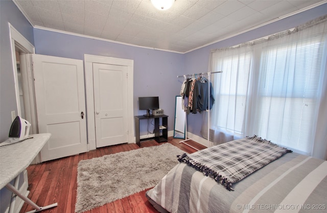 bedroom featuring ornamental molding and dark hardwood / wood-style floors