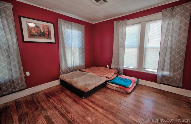 bedroom featuring wood-type flooring and ornamental molding