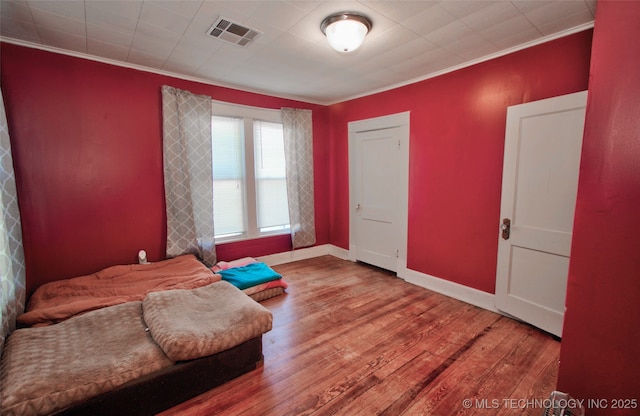 living area featuring crown molding and wood-type flooring