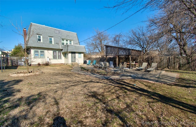 rear view of property featuring a lawn and a patio