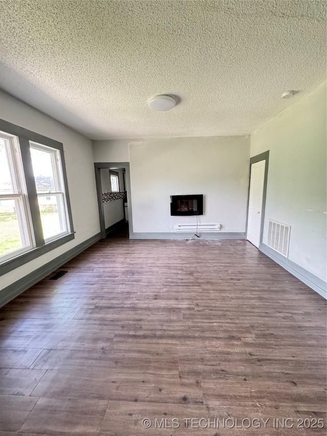 unfurnished living room with hardwood / wood-style floors and a textured ceiling