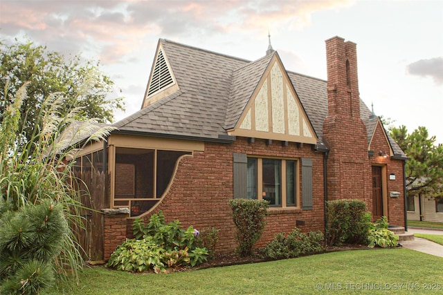 view of home's exterior with a sunroom and a lawn