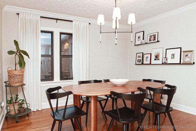 dining room featuring hardwood / wood-style flooring, crown molding, a textured ceiling, and a notable chandelier