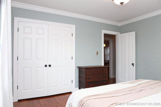 bedroom featuring crown molding, dark wood-type flooring, and a closet