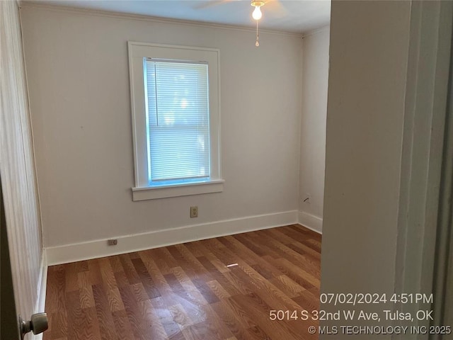 empty room featuring hardwood / wood-style flooring, ornamental molding, and ceiling fan