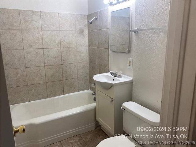 full bathroom featuring tile patterned flooring, vanity, tiled shower / bath, and toilet