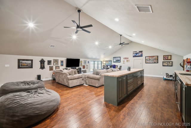 kitchen with wooden counters, vaulted ceiling, dark hardwood / wood-style floors, a kitchen island, and ceiling fan