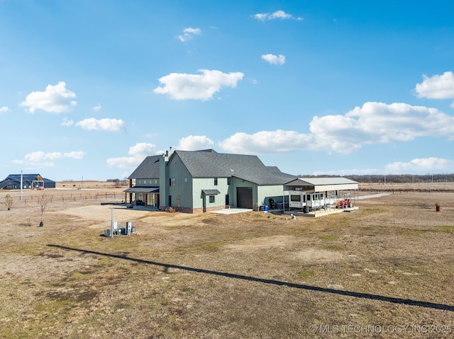 rear view of property with a yard and a rural view