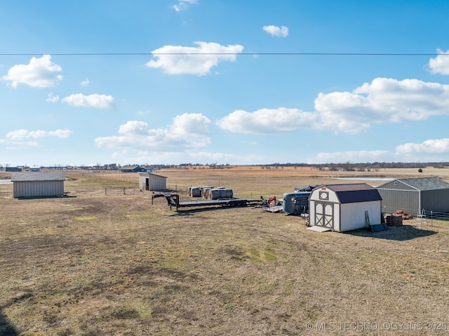 view of yard featuring a storage shed and a rural view