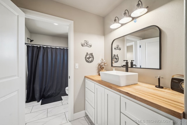 bathroom featuring vanity, curtained shower, and toilet