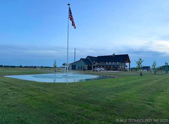 view of home's community with a yard and a water view