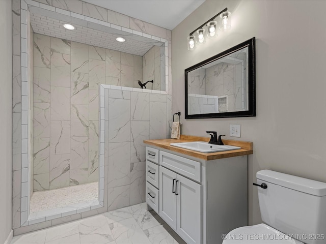 bathroom with vanity, toilet, and a tile shower