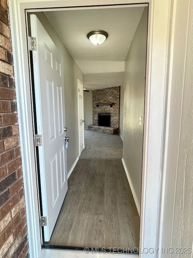 hallway featuring dark hardwood / wood-style floors and a textured ceiling