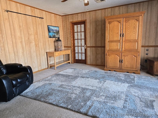 living room featuring ceiling fan, light colored carpet, and a textured ceiling