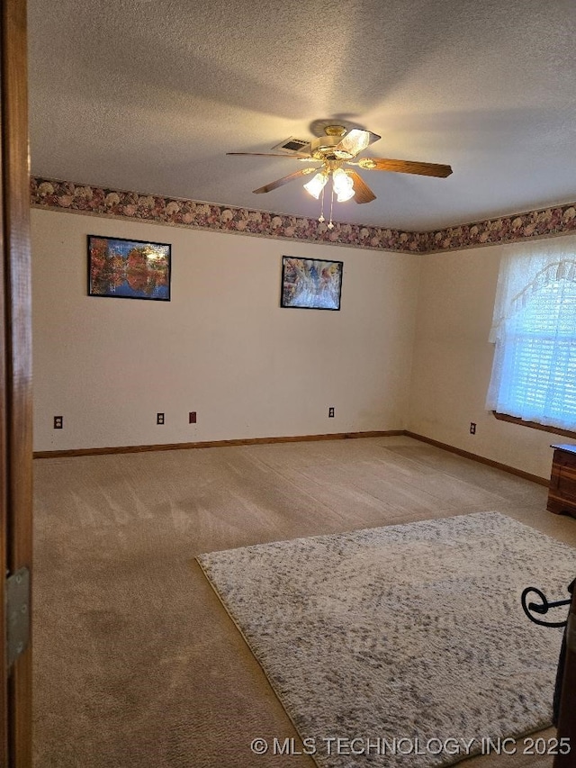 carpeted empty room with a textured ceiling and ceiling fan