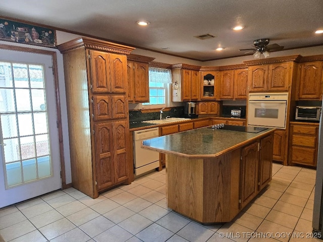 kitchen with white appliances, a wealth of natural light, ornamental molding, and a kitchen island