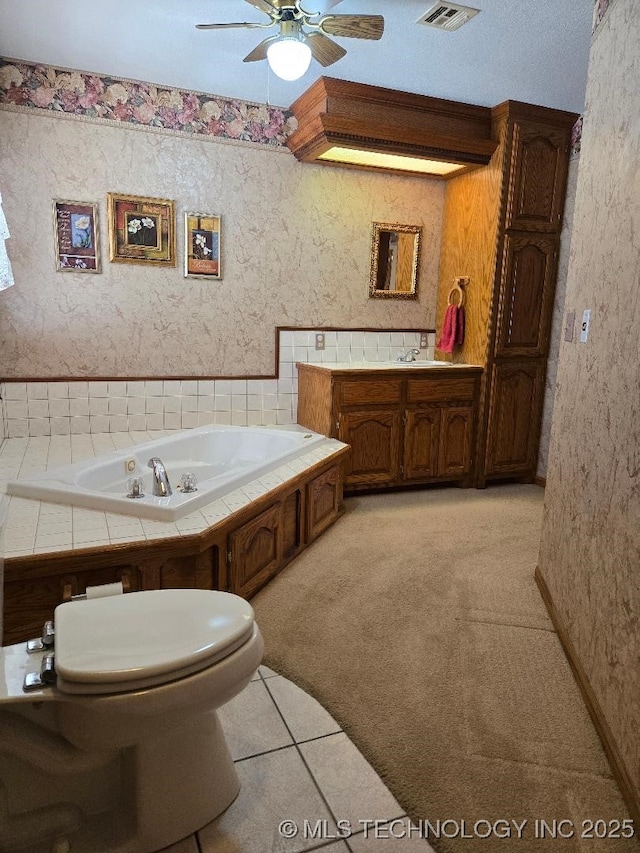 bathroom featuring ceiling fan, a bathtub, vanity, tile patterned floors, and toilet