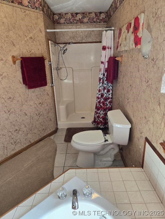 bathroom with a shower with curtain, tile patterned floors, and toilet