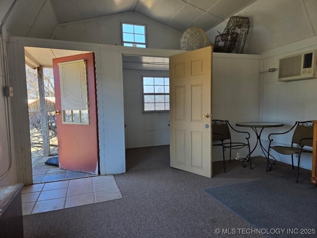 carpeted entrance foyer featuring vaulted ceiling and an AC wall unit