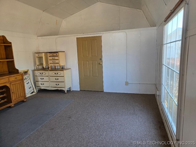 carpeted empty room with vaulted ceiling