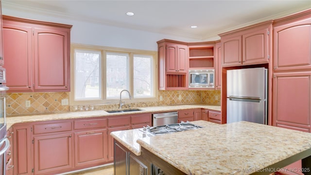 kitchen with tasteful backsplash, ornamental molding, appliances with stainless steel finishes, and sink