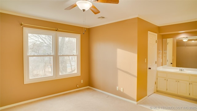 spare room with light carpet, sink, ornamental molding, and ceiling fan