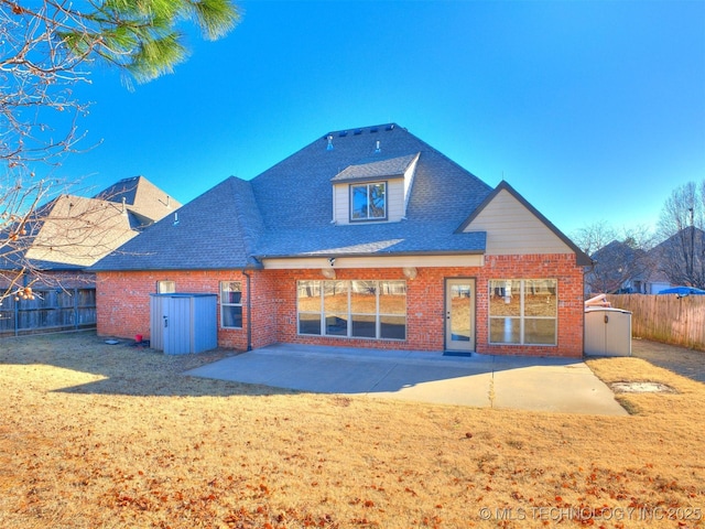 back of property with brick siding, a fenced backyard, a yard, and a patio