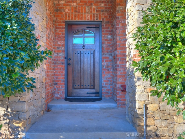 doorway to property with brick siding