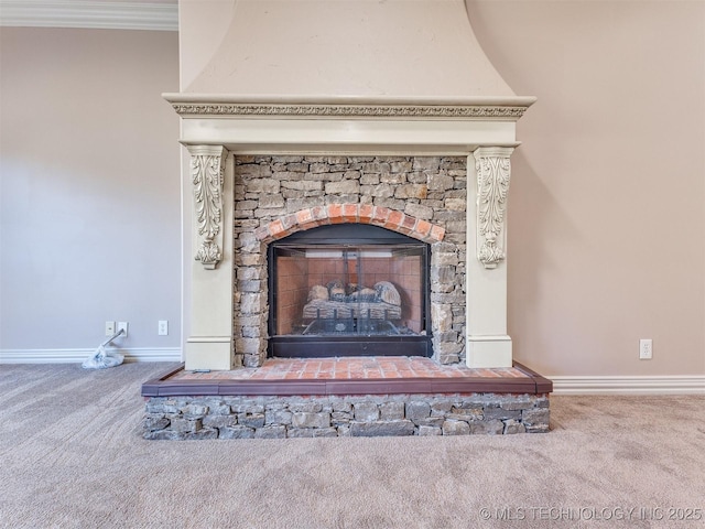 room details featuring a stone fireplace, ornamental molding, and carpet