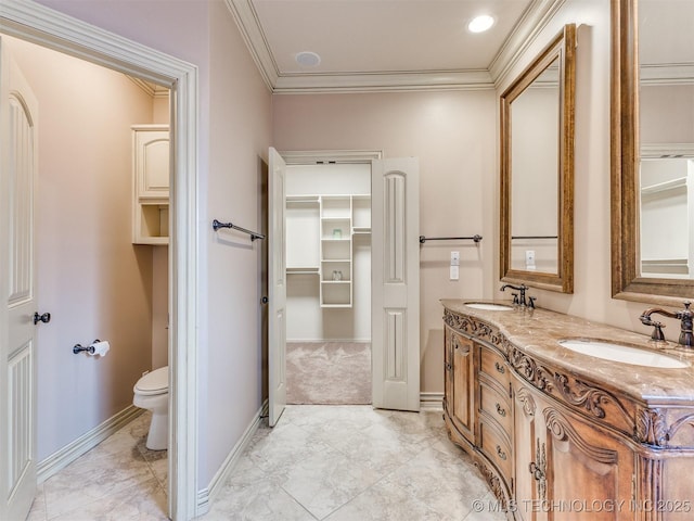 bathroom with double vanity, toilet, crown molding, and a sink