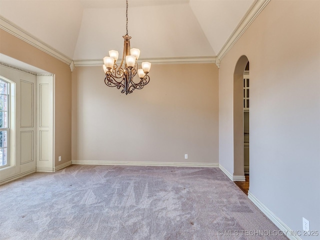 carpeted empty room with crown molding, plenty of natural light, high vaulted ceiling, and a notable chandelier