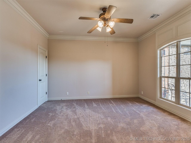 carpeted spare room with baseboards, visible vents, a wealth of natural light, and ornamental molding